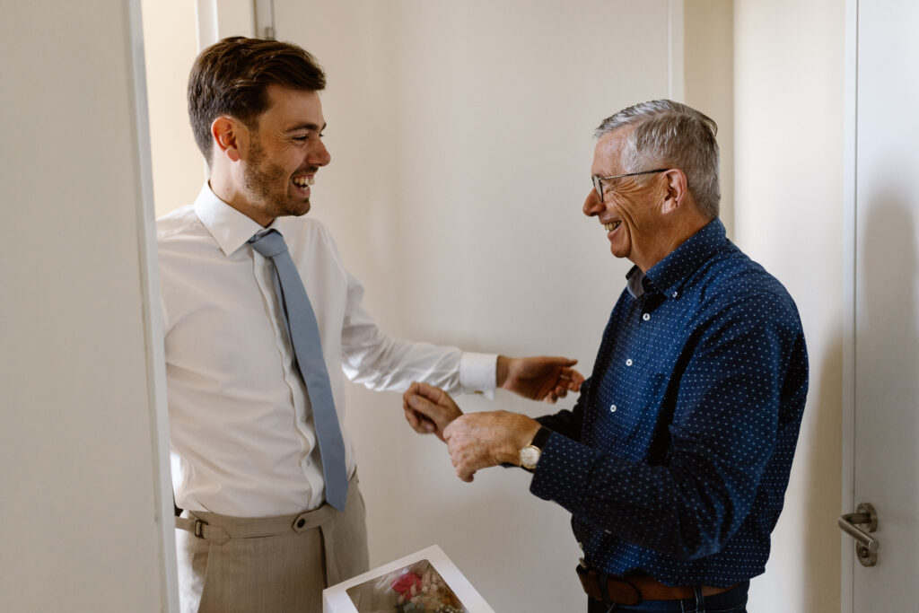 Bruidegom kleedt zich aan in een aparte kamer tijdens de ochtend van hun trouwdag in Utrecht.