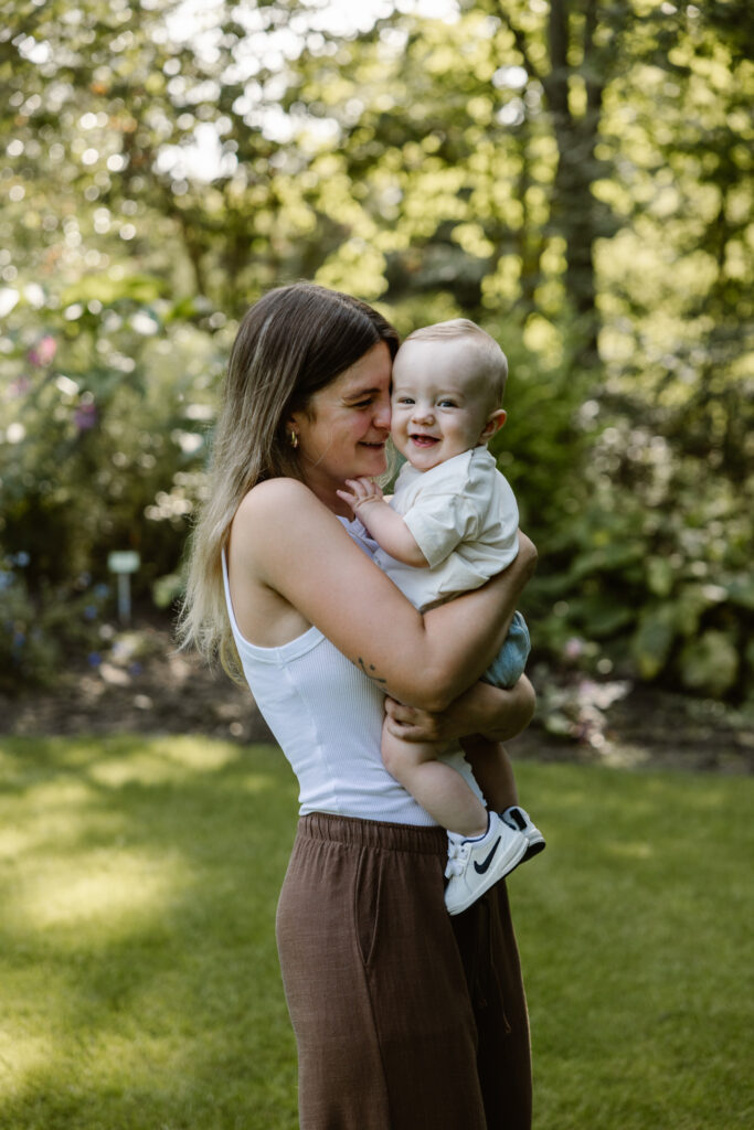 Een speels moment tussen moeder en kind onder de grote bomen van Trompenburg Rotterdam.