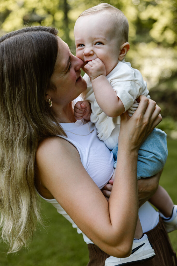 Een speels moment tussen moeder en kind onder de grote bomen van Trompenburg Rotterdam.