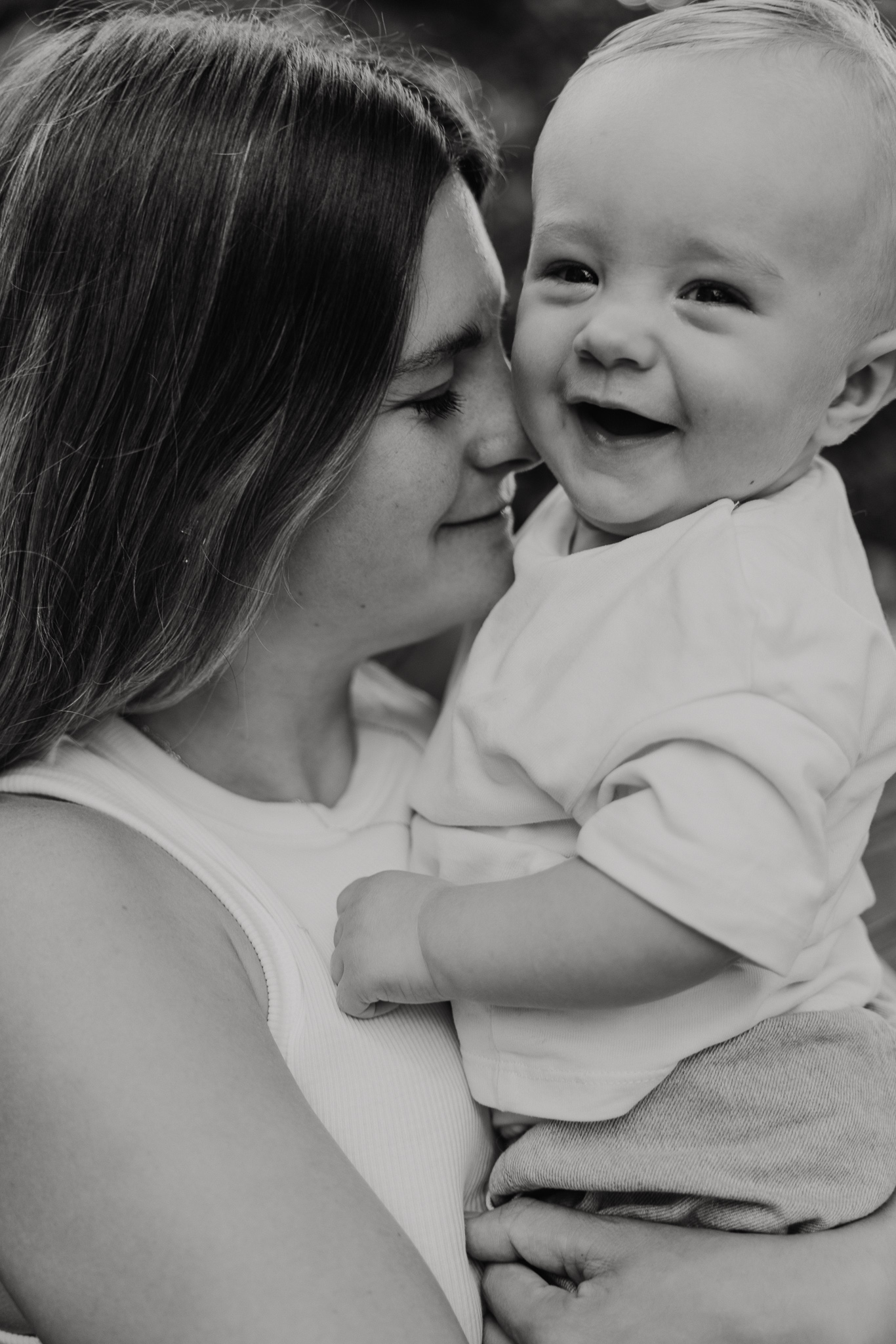 Mama knuffelt haar baby tijdens een ontspannen moeder-en-kind fotoshoot in de natuur.