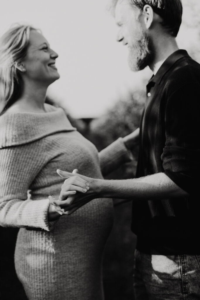 Detailfoto van babybuik tijdens een liefdevolle fotoshoot in de natuur bij Rotterdam.