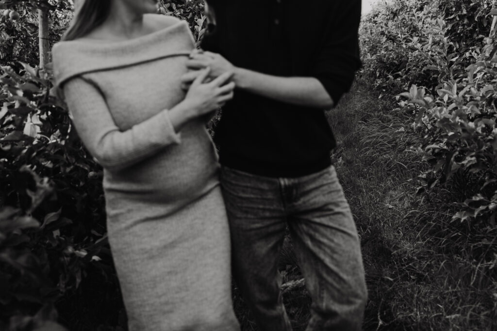 Detailfoto van babybuik tijdens een liefdevolle fotoshoot in de natuur bij Rotterdam.