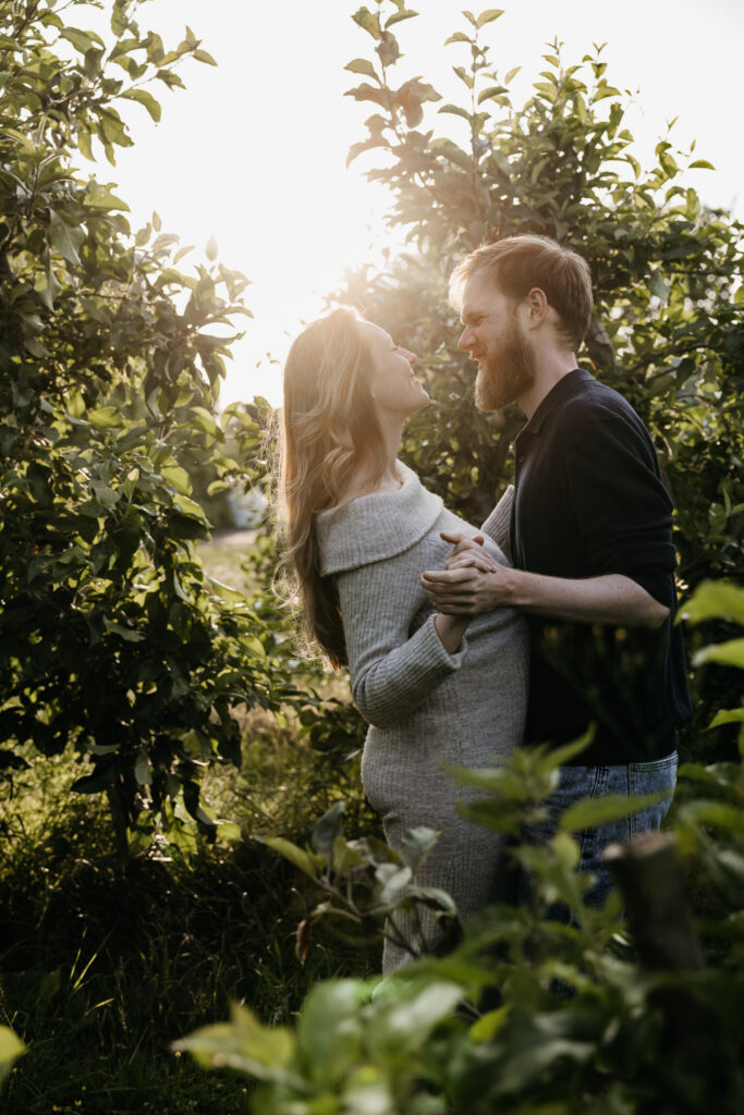 Aanstaand stel danst vrolijk in het gras tijdens hun zwangerschapsfotografie sessie in Rhoon.