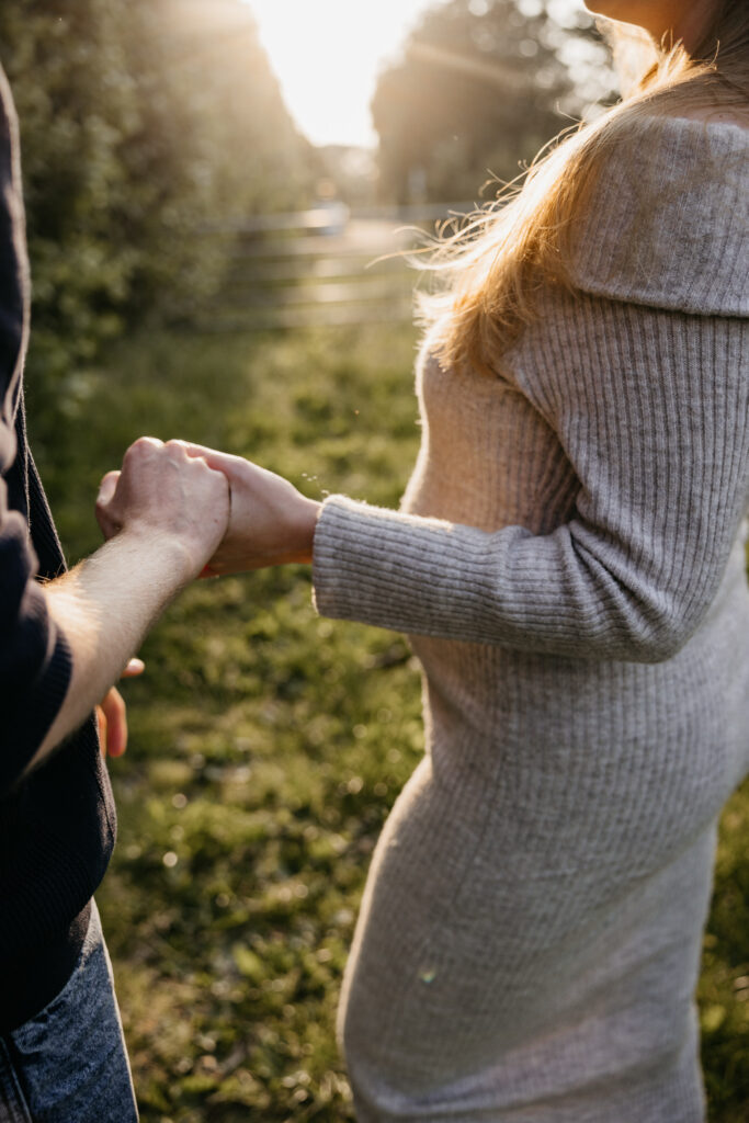 Detailfoto van babybuik tijdens een liefdevolle fotoshoot in de natuur bij Rotterdam.