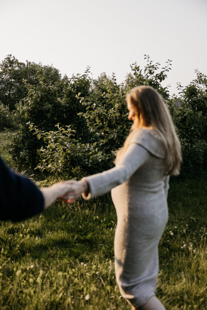 Zachte zwangerschapsshoot tussen de appelbomen bij De Buytenhof in Rhoon tijdens zonsondergang