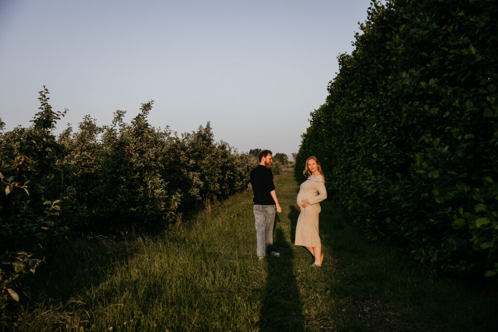 Ongedwongen en spontane foto van een zwangere vrouw die wandelt door de boomgaard in Rhoon.