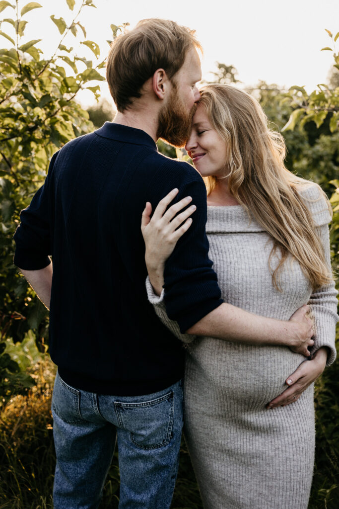 Romantische zwangerschapsfoto met tegenlicht tijdens het gouden uurtje in de regio Rotterdam.