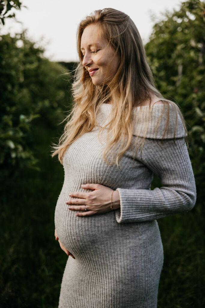 Ongedwongen en spontane foto van een zwangere vrouw die wandelt door de boomgaard in Rhoon.