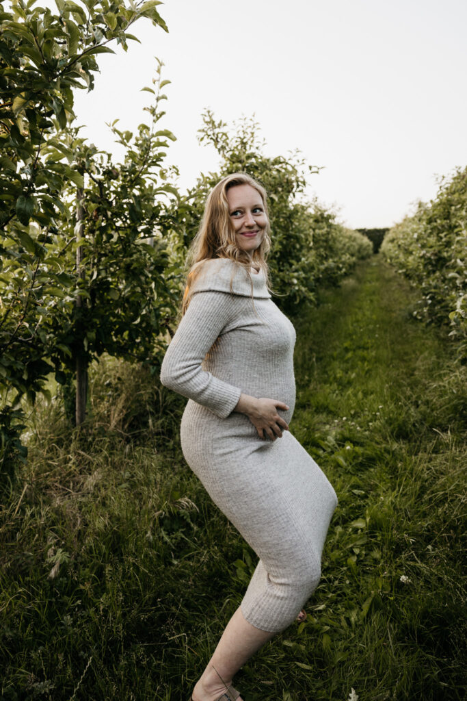 Ongedwongen en spontane foto van een zwangere vrouw die wandelt door de boomgaard in Rhoon.