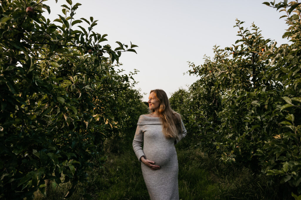 Ongedwongen en spontane foto van een zwangere vrouw die wandelt door de boomgaard in Rhoon.