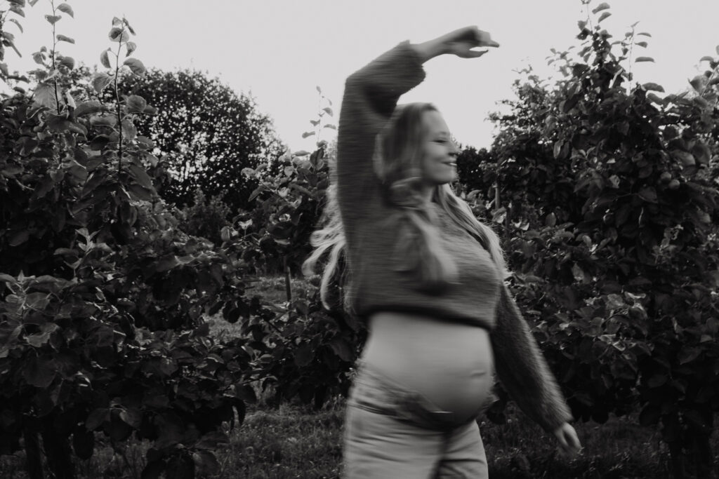 Ongedwongen en spontane foto van een zwangere vrouw die wandelt door de boomgaard in Rhoon.