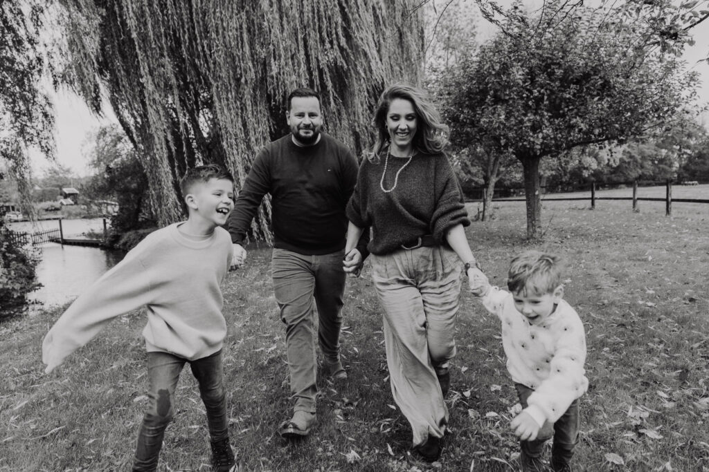 Familie knuffelt buiten op het gras tijdens een familie fotoshoot in Rotterdam.