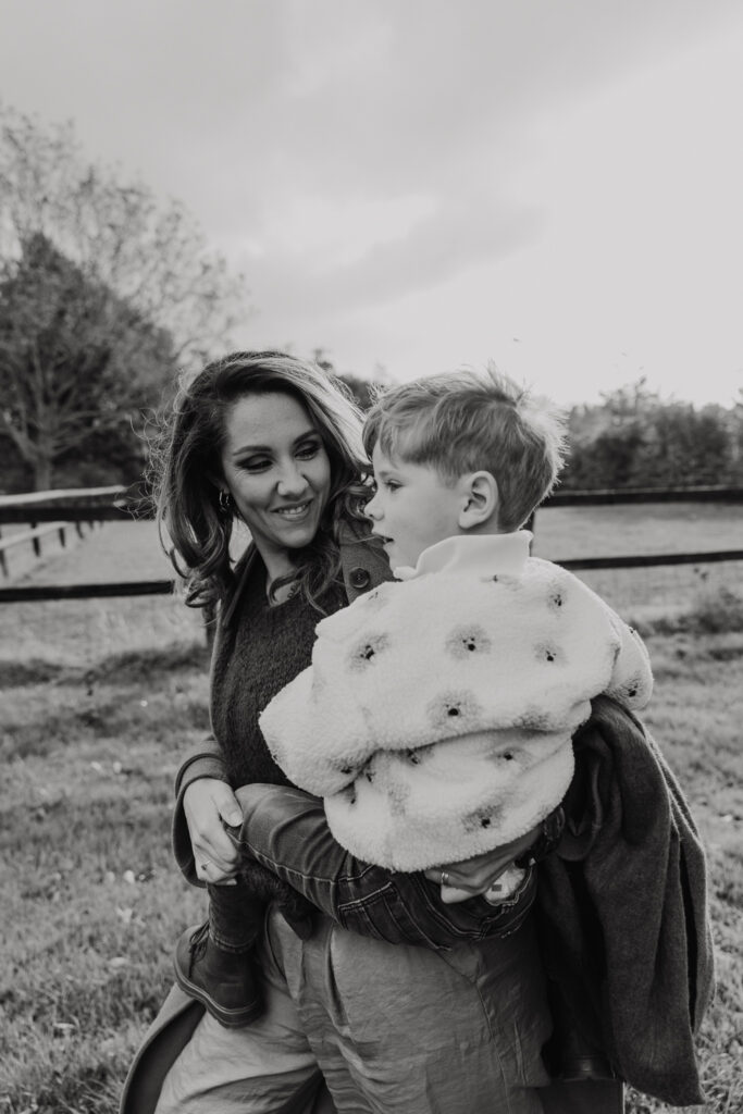 Gezin samen lachend in de achtertuin tijdens een fotoshoot familie in vertrouwde omgeving.