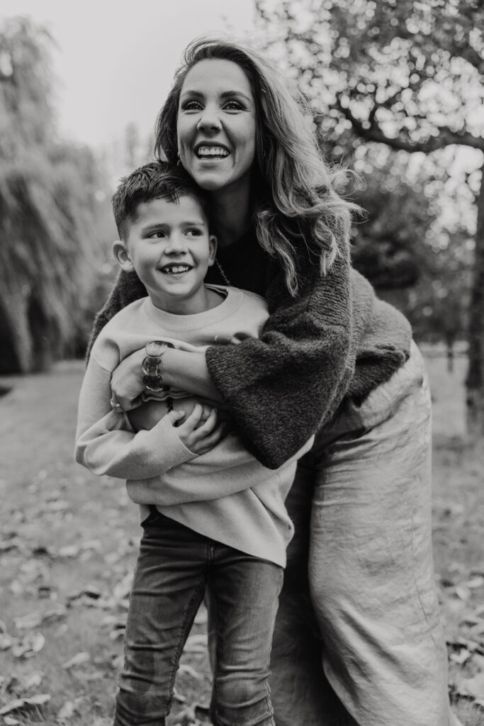 Gezin samen lachend in de achtertuin tijdens een fotoshoot familie in vertrouwde omgeving.