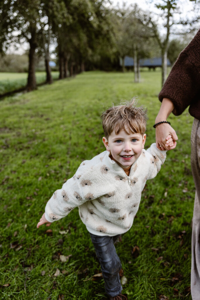 Gezin samen lachend in de achtertuin tijdens een fotoshoot familie in vertrouwde omgeving.