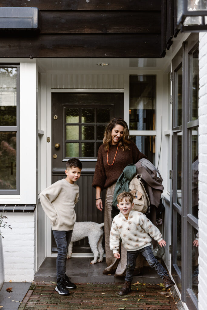 Gezin samen lachend in de achtertuin tijdens een fotoshoot familie in vertrouwde omgeving.