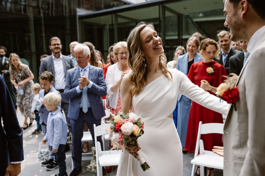 Bruidspaar omringd door gasten tijdens hun trouwceremonie in Utrecht stad.