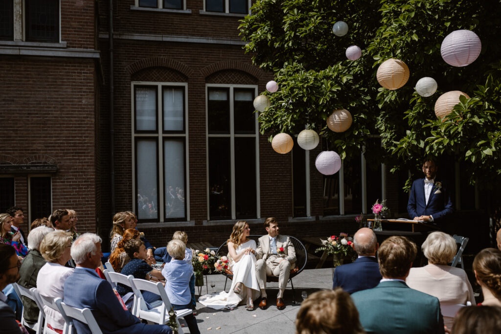 Bruidspaar omringd door gasten tijdens hun trouwceremonie in Utrecht stad.