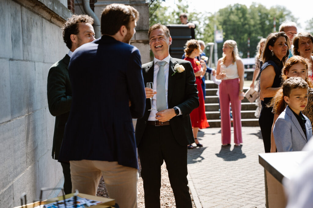 Taart aansnijden voor het Muntgebouw tijdens een zonnige bruiloft in Utrecht.