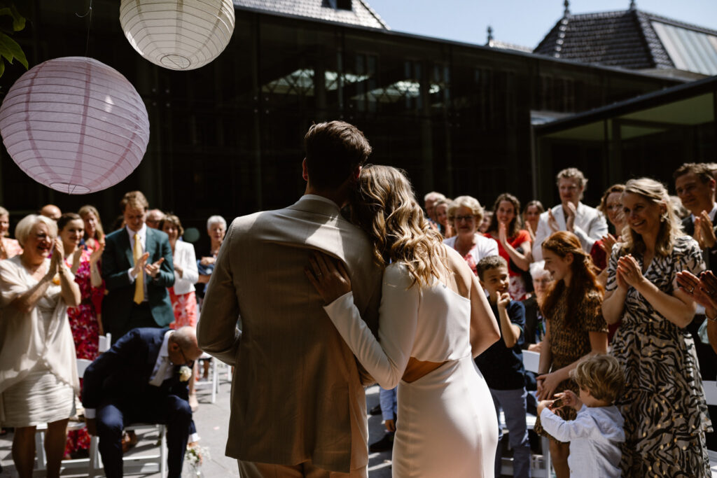 Bruidspaar omringd door gasten tijdens hun trouwceremonie in Utrecht stad.