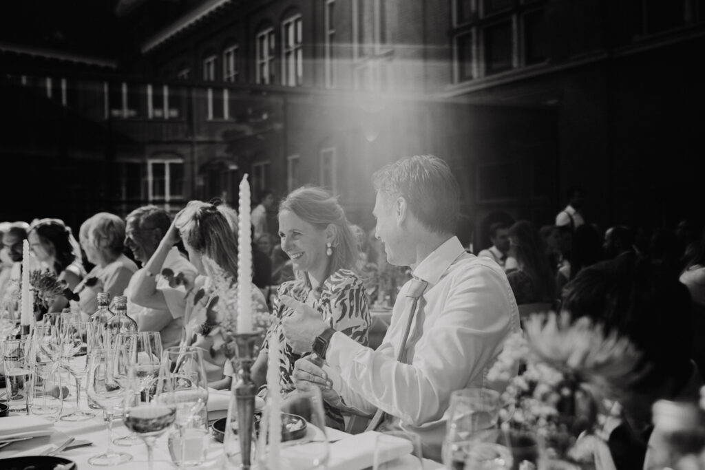 Intiem moment tijdens diner op de binnenplaats van het Muntgebouw tijdens een bruiloft in Utrecht.