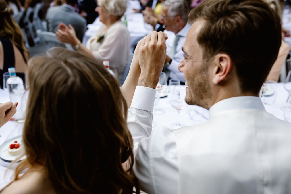 Intiem moment bruidspaar tijdens diner op de binnenplaats van het Muntgebouw tijdens een bruiloft in Utrecht.