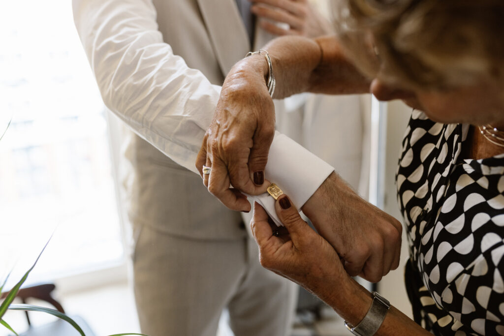 Bruidegom kleedt zich aan in een aparte kamer tijdens de ochtend van hun trouwdag in Utrecht.