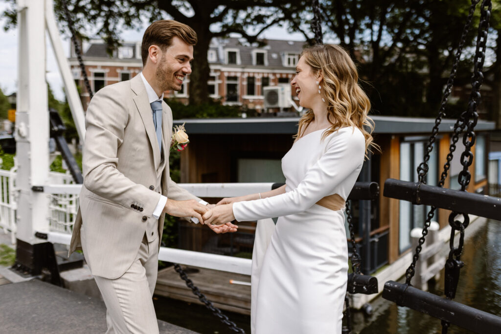Portret van het bruidspaar bij het water tegenover het Muntgebouw in Utrecht.