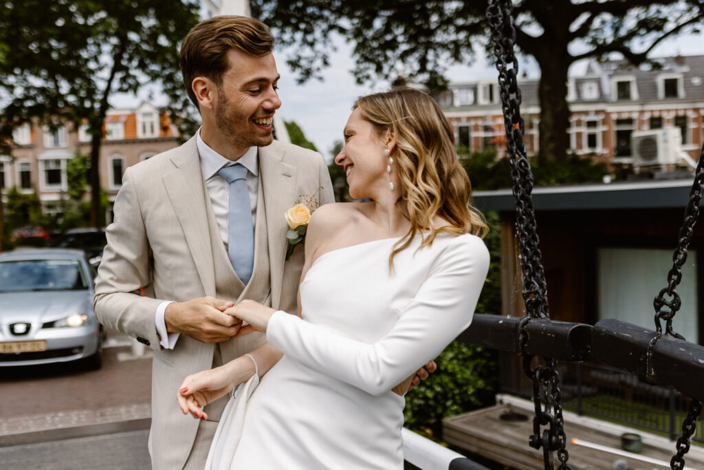 Portret van het bruidspaar bij het water tegenover het Muntgebouw in Utrecht.