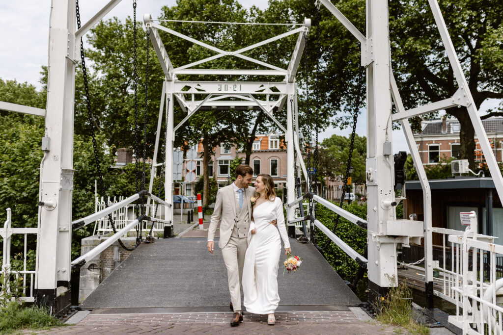 Portret van het bruidspaar bij het water tegenover het Muntgebouw in Utrecht.