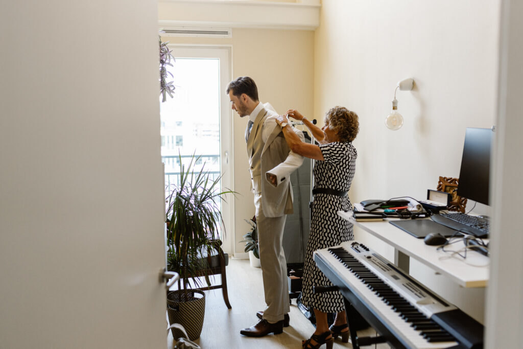 Bruidegom kleedt zich aan in een aparte kamer tijdens de ochtend van hun trouwdag in Utrecht.