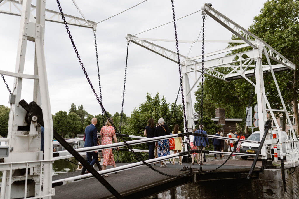 Gasten wachten enthousiast aan de waterkant bij het Muntgebouw Utrecht.