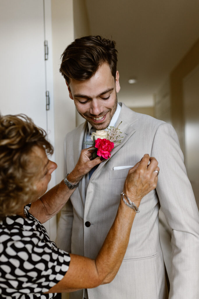 Bruidegom kleedt zich aan in een aparte kamer tijdens de ochtend van hun trouwdag in Utrecht.