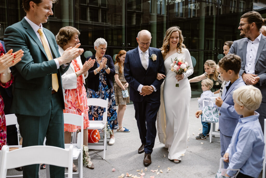 Bruidspaar omringd door gasten tijdens hun trouwceremonie in Utrecht stad.
