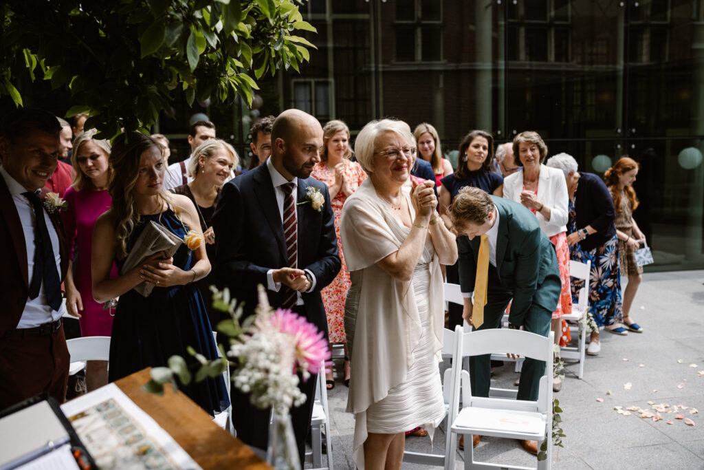 Bruidspaar omringd door gasten tijdens hun trouwceremonie in Utrecht stad.