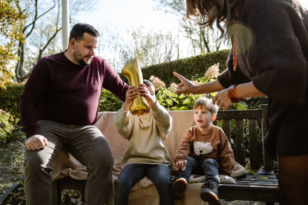 Ouders vertellen hun kinderen over zwangerschap tijdens een familie fotoshoot.