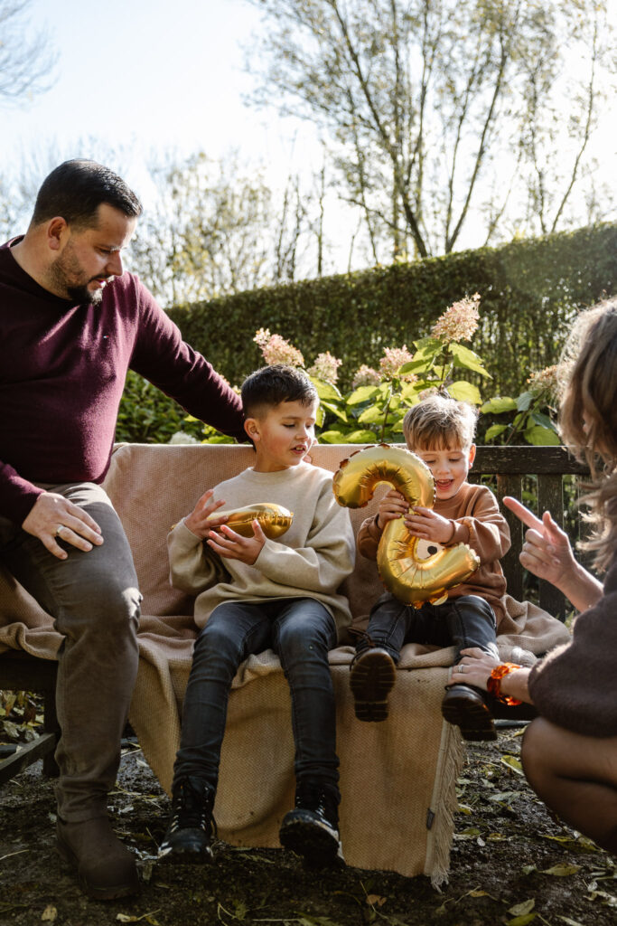 Ouders vertellen hun kinderen over zwangerschap tijdens een familie fotoshoot.